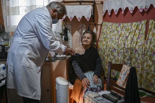 Доктор Анаргирос Мариолис вакцинирует пожилую женщину от COVID-19 на острове Элафониссос Доктор Анаргирос Мариолис вакцинирует пожилую женщину от COVID-19 на острове Элафониссос - Sputnik Латвия
