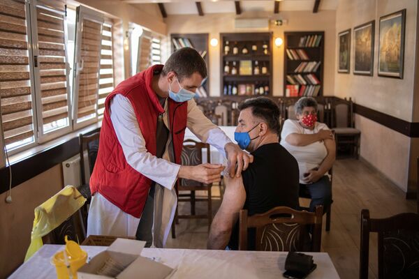 Мужчина получает дозу китайской вакцины Sinopharm против коронавирусной болезни (COVID-19) в ресторане в Крагуеваце, Сербия Мужчина получает дозу китайской вакцины Sinopharm против коронавирусной болезни (COVID-19) в ресторане в Крагуеваце, Сербия - Sputnik Латвия