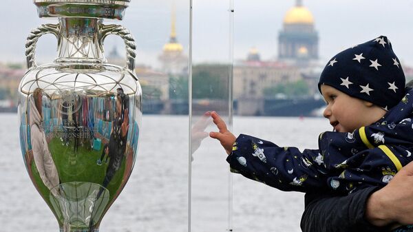 Ребенок рядом с кубком Европы по футболу, представленным в Санкт-Петербурге - Sputnik Латвия
