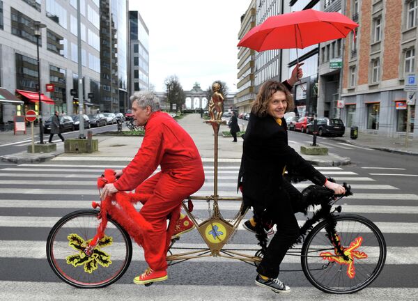 Divi beļģi - flāms (melnā) un valonis (sarkanajā) - brauc ar vienu velosipēdu pretējos virzienos, kas simbolizē pretrunas starp valsts valodas kopienām, 2011. gada janvāris. - Sputnik Latvija
