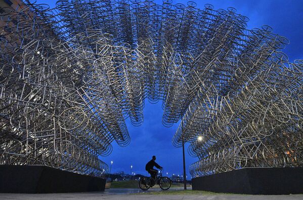 Велосипедист проезжает через инсталляцию &quot;Велосипеды навсегда&quot; в Рио-де-Жанейро, 2019 год. Инсталляцию составили из более чем тысячи велосипедов из нержавеющей стали. - Sputnik Латвия