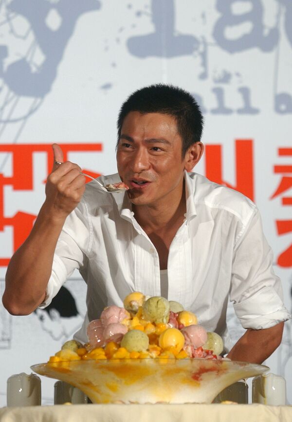 Гонконгский актер и певец Энди Лау лакомится мороженым на Тайване, 23 августа 2005 года. - Sputnik Латвия