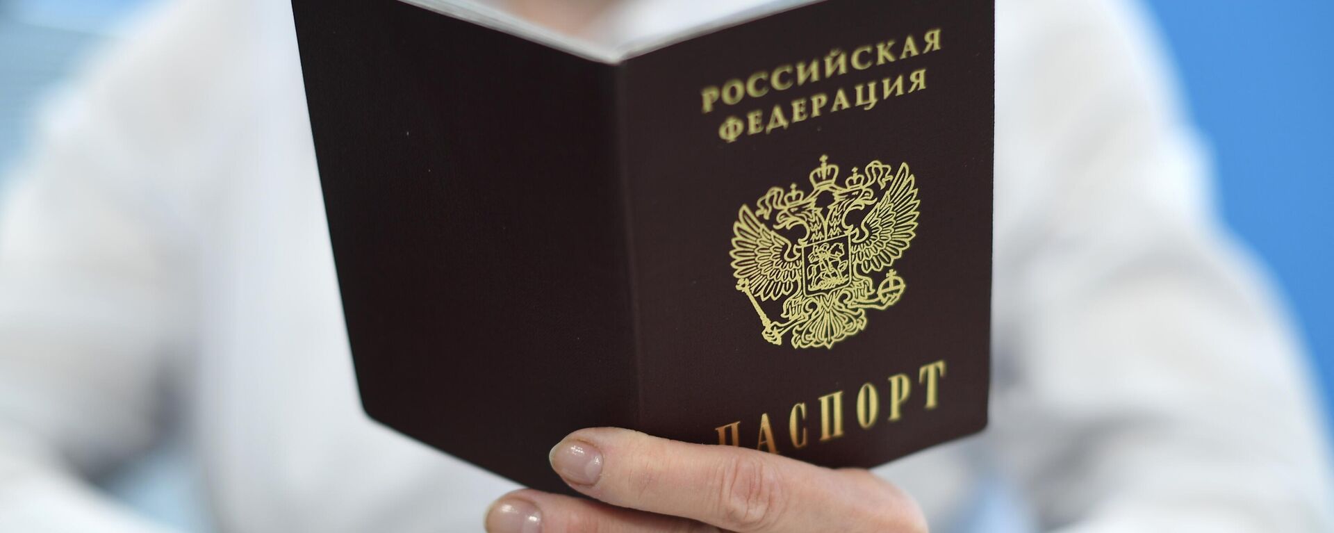 Сотрудник ПФР держит в руках паспорт РФ - Sputnik Латвия, 1920, 16.08.2023