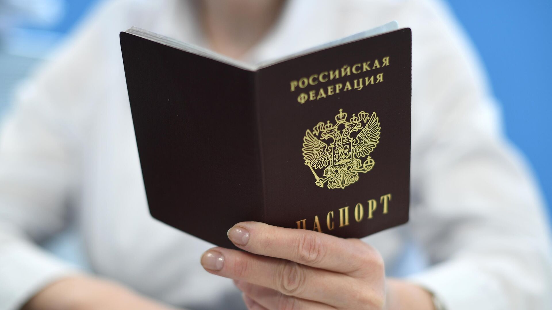 Сотрудник ПФР держит в руках паспорт РФ - Sputnik Латвия, 1920, 16.05.2021
