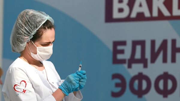 Медицинский работник держит в руках шприц с вакциной Гам-Ковид-Вак (Спутник V) от COVID-19 - Sputnik Latvija