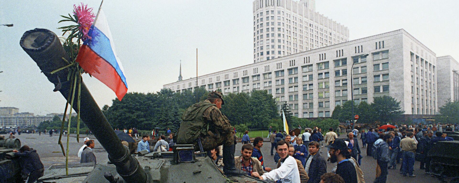 Защитники Белого дома прикрепили цветы к орудийному стволу одного из танков, введенных в Москву 19 августа 1991 года в связи с объявлением членами ГКЧП чрезвычайного положения в столице - Sputnik Latvija, 1920, 24.12.2021