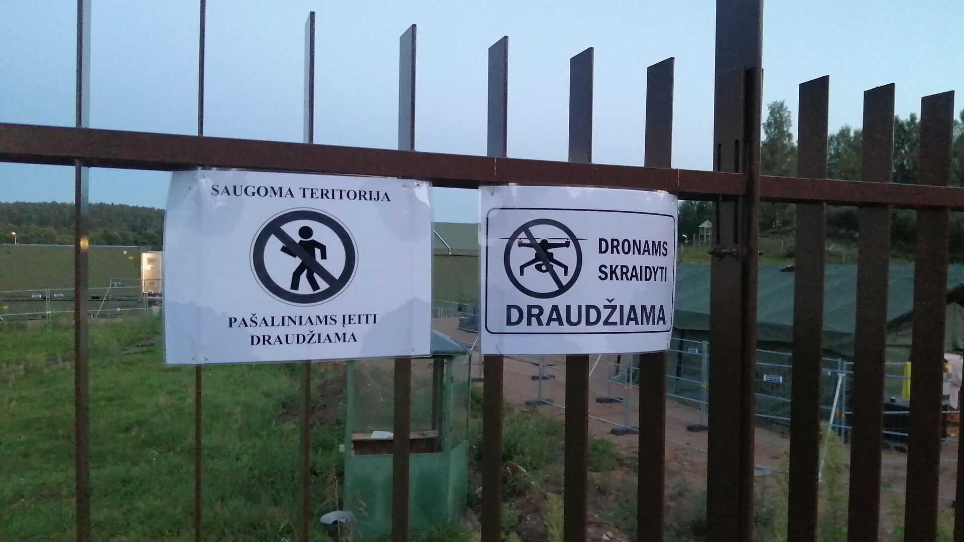 Предупреждающие знаки на заборе рядом с палаточным лагерем для мигрантов в Литве - Sputnik Latvija, 1920, 24.10.2021