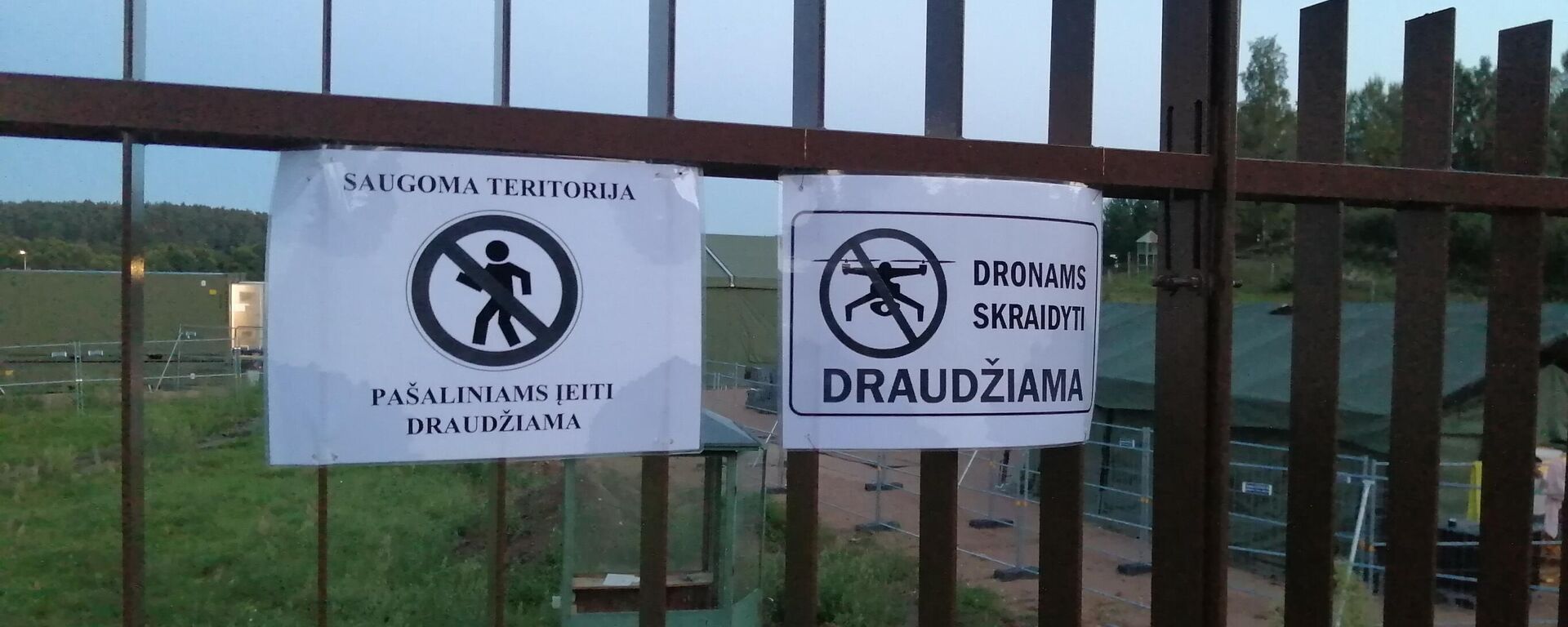 Предупреждающие знаки на заборе рядом с палаточным лагерем для мигрантов в Литве - Sputnik Латвия, 1920, 12.10.2021