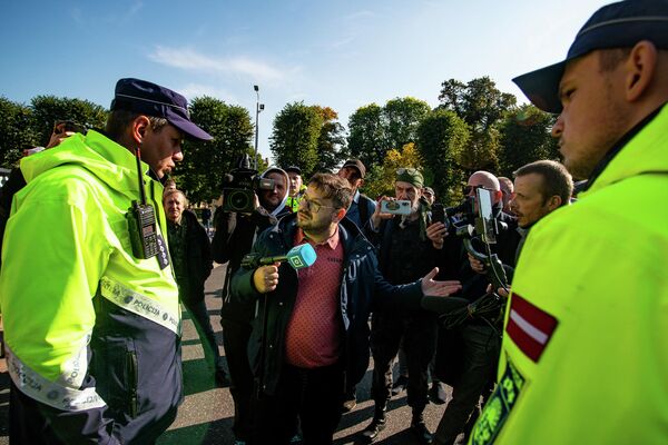 Latvijas televīzijas žurnālists Aleksejs Dunda lūdz policijas darbiniekus aizsargāt viņu un operatoru no uzmācīgiem protestētājiem Latvijas televīzijas žurnālists Aleksejs Dunda lūdz policijas darbiniekus aizsargāt viņu un operatoru no uzmācīgiem protestētājiem - Sputnik Latvija