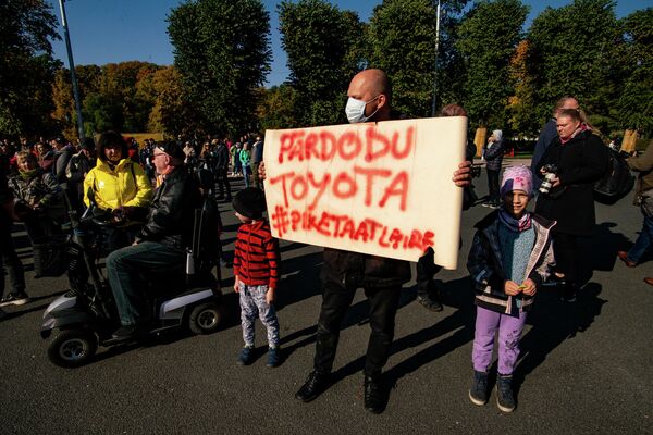 Vīrietis ar plakātu "Pārdodu Toyota" protesta akcijā pie Brīvības pieminekļa Vīrietis ar plakātu "Pārdodu Toyota" protesta akcijā pie Brīvības pieminekļa - Sputnik Latvija