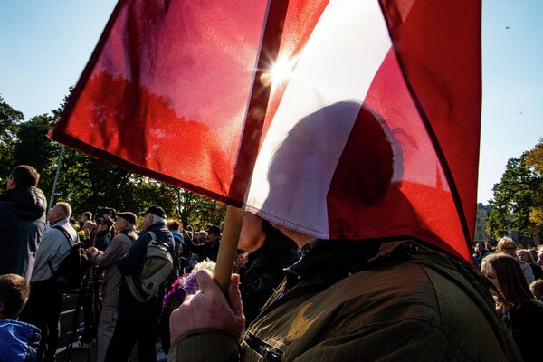 Vīrietis ar Latvijas karogu protesta akcijā pie Brīvības pieminekļa Vīrietis ar Latvijas karogu protesta akcijā pie Brīvības pieminekļa - Sputnik Latvija