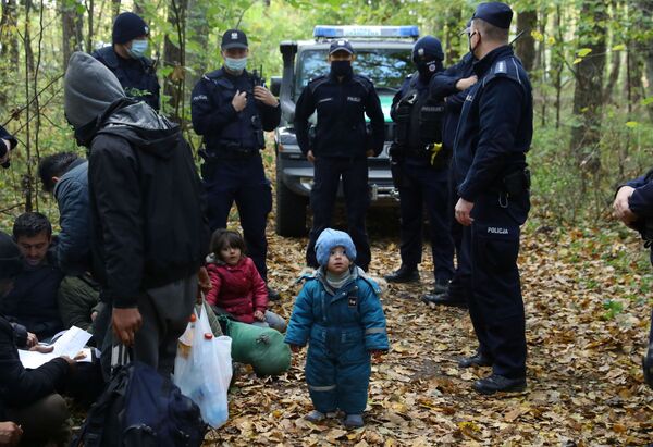 Nelegāli migranti un robežsargi uz Polijas un Baltkrievijas robežas pie Hajnuvkas pilsētas, Polija. Nelegāli migranti un robežsargi uz Polijas un Baltkrievijas robežas pie Hajnuvkas pilsētas, Polija. - Sputnik Latvija