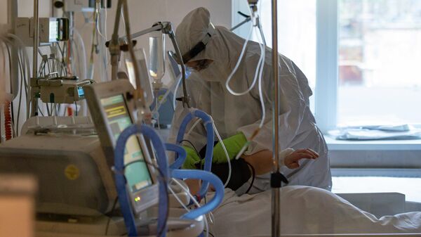 Медицинский работник у кровати пациента с COVID-19 в Центре легочных заболеваний и туберкулеза в Даугавпилсе - Sputnik Latvija