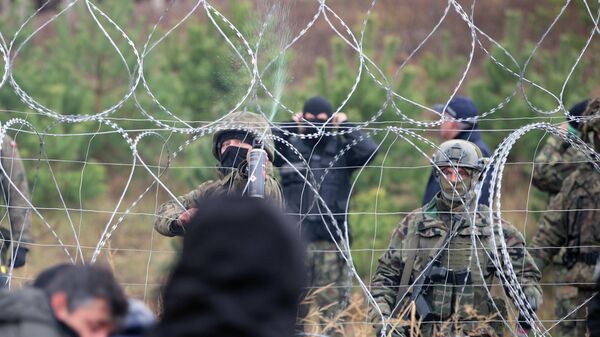Польский военнослужащий распыляет слезоточивый газ в сторону нелегальных мигрантов на польско-белорусской границе - Sputnik Латвия