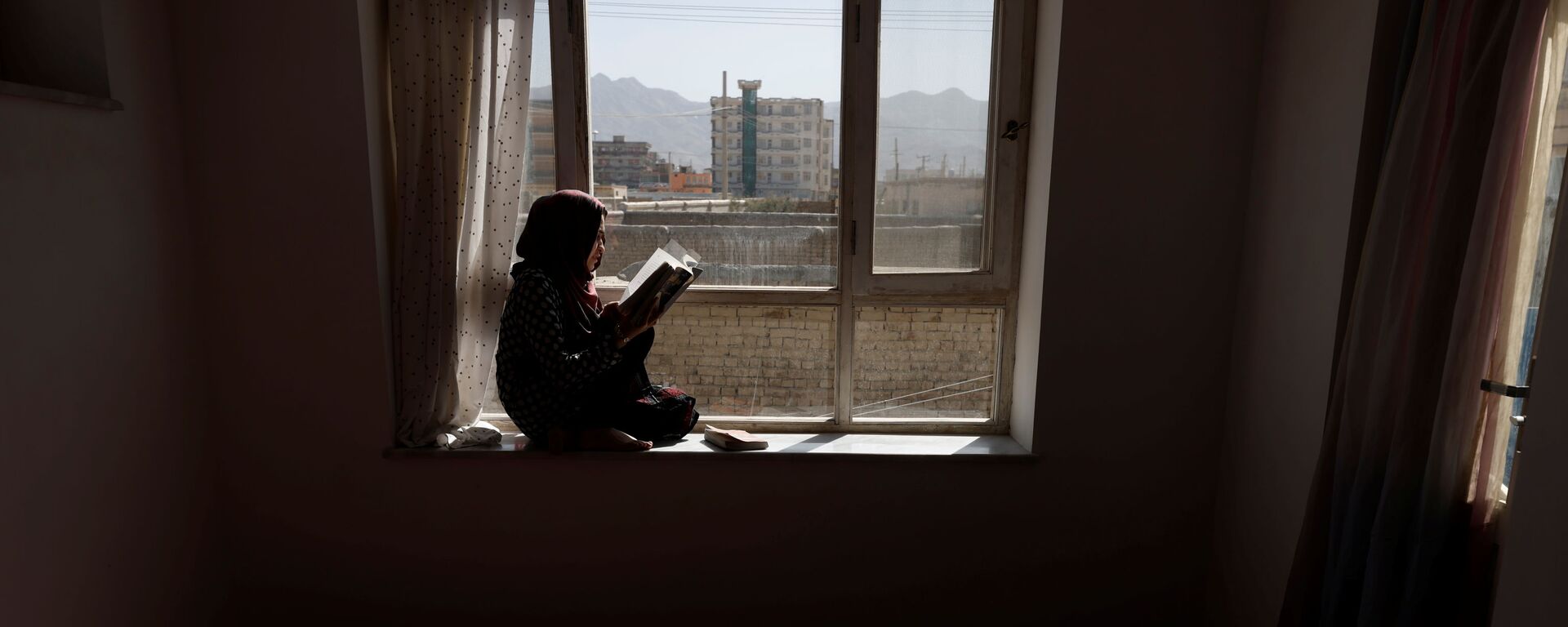 20-летняя студентка Хава читает книгу на подоконнике своего дома в Кабуле, Афганистан - Sputnik Latvija, 1920, 10.11.2021