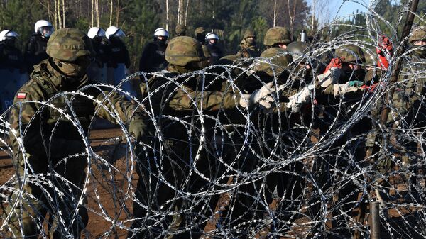 Польские военнослужащие устанавливают забор из колючей проволоки на польско-белорусской границе - Sputnik Латвия