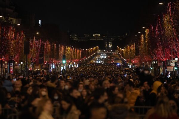 Cilvēki vēro svētku apgaismojuma iedegšanas ceremoniju Elizejas laukos Parīzē. - Sputnik Latvija