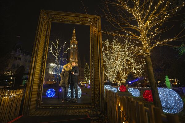 Pāris pozē pie rātsnama Ziemassvētku tirdziņā Vīnē. - Sputnik Latvija