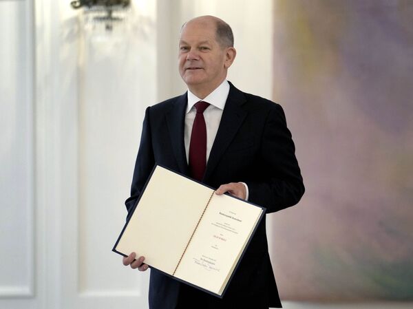 Новоизбранный канцлер Германии Олаф Шольц держит письмо о назначении во время приема во дворце Бельвю в Берлине, Германия. - Sputnik Латвия