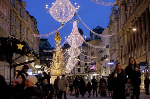 Люди ходят под рождественскими огнями в Вене, Австрия. Магазины и рестораны закрыты из-за падемии коронавируса. - Sputnik Латвия