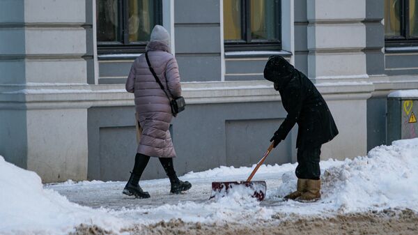Дворник убирает снег в Риге - Sputnik Латвия