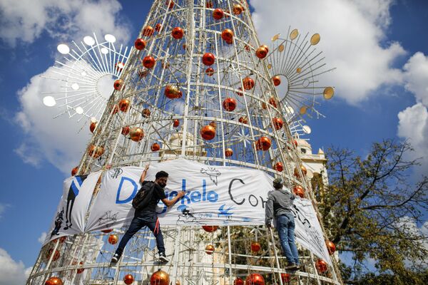 Активисты вешают баннер на елку во время акции протеста в Сан-Сальвадоре. - Sputnik Латвия