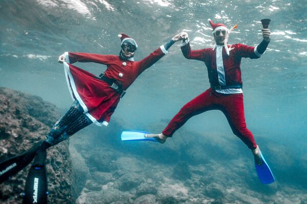 Фридайверы, одетые в костюмы Санта-Клауса, фотографируются под водой у побережья ливанского города Батрун. - Sputnik Латвия