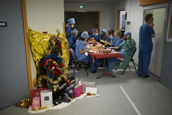 Детский врач Том Баллас смотрит в палату пациента, пока другие врачи и медсестры обедают вместе в канун Рождества в отделении интенсивной терапии COVID-19 в больнице Ла Тимон в Марселе, на юге Франции. - Sputnik Латвия