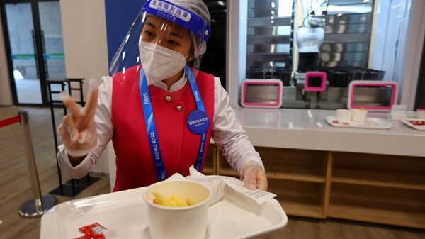 Персонал кафе подает еду  в обеденном зале Главного пресс-центра Олимпийских игр 2022 года в Пекине - Sputnik Латвия