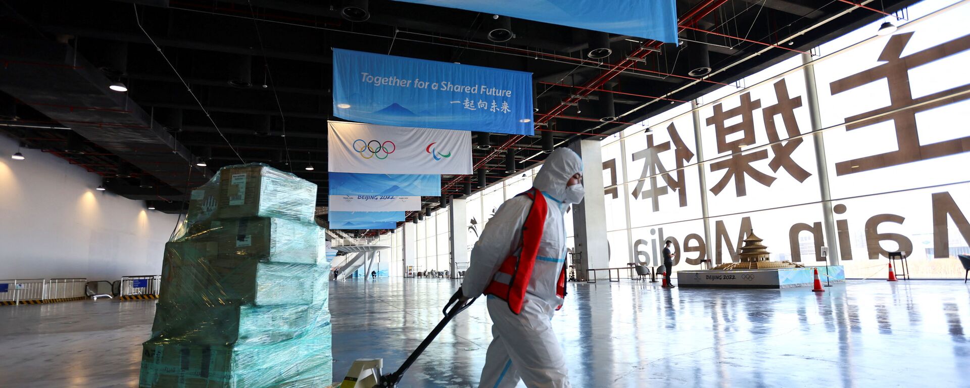 Рабочий в защитном костюме в Главном пресс-центре перед зимними Олимпийскими играми 2022 года в Пекине - Sputnik Латвия, 1920, 25.01.2022