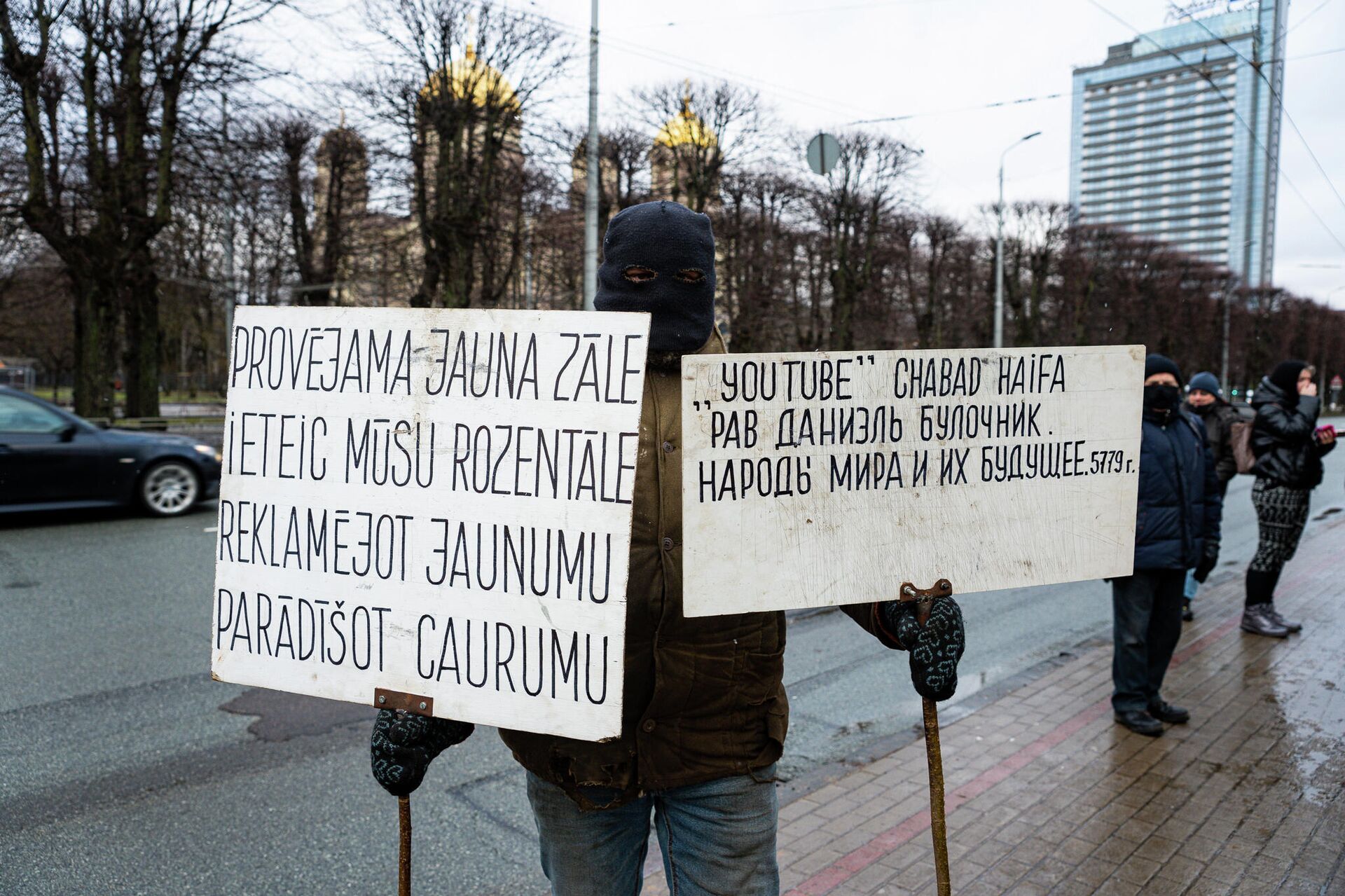 Протестующий с плакатами на открытии памятника Гунару Астре Протестующий с плакатами на открытии памятника Гунару Астре - Sputnik Латвия, 1920, 20.01.2022