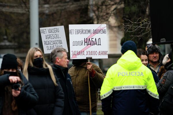 Protestētājs ar plakātiem Gunāram Astram veltītā pieminekļa atklāšanā Rīgā. - Sputnik Latvija