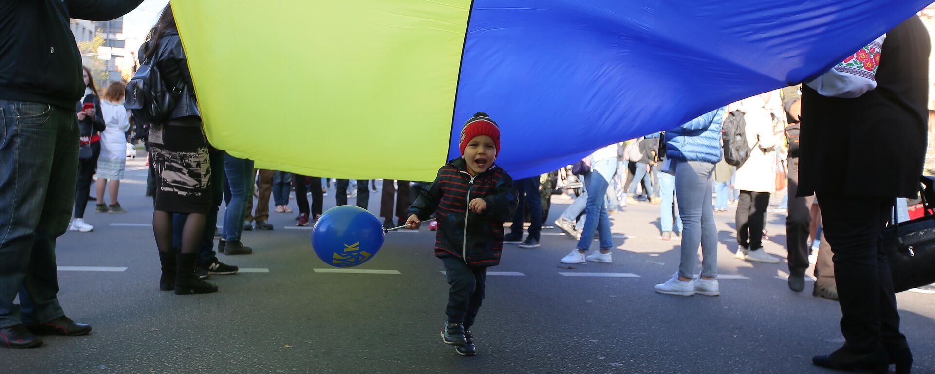 Люди с украинским флагом во время марша националистов - Sputnik Латвия, 1920, 02.03.2022