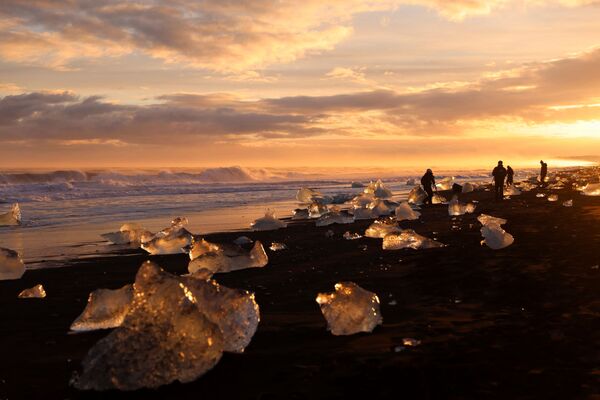 На рассвете отколовшиеся куски от айсберга можно запросто принять за огромной величины розовые и желтые алмазы. - Sputnik Латвия