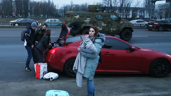 Люди кладут свои вещи в машину на одной из улиц в Киеве - Sputnik Латвия