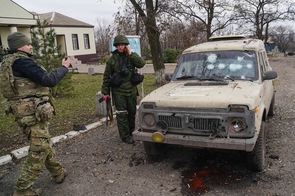 Doņeckas Tautas Republikas miliči un Krievijas BS karavīri pie Ukrainas armijas apšaudītā automobiļa Nikolajevkas ciematā. - Sputnik Latvija