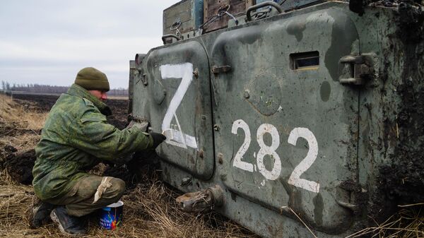 Военнослужащий народной милиции ДНР наносит знак Z на бронетехнику под Волновахой - Sputnik Латвия