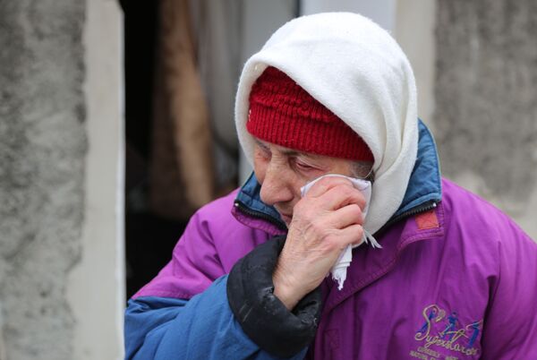 Пожилая женщина плачет около жилого дома в Киевском районе Донецка, разрушенном в результате обстрела - Sputnik Латвия
