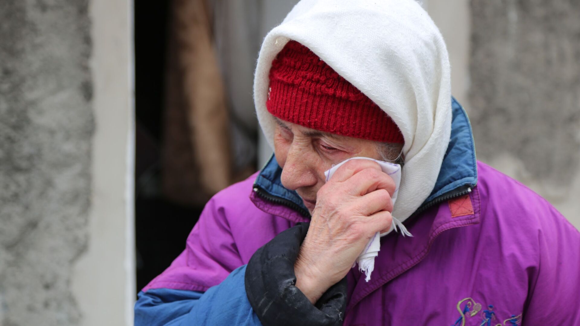 Пожилая женщина плачет около жилого дома в Киевском районе Донецка, разрушенном в результате обстрела - Sputnik Latvija, 1920, 17.03.2022