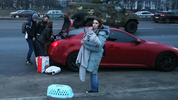 Люди собирают вещи в машину на одной из улиц в Киеве - Sputnik Latvija