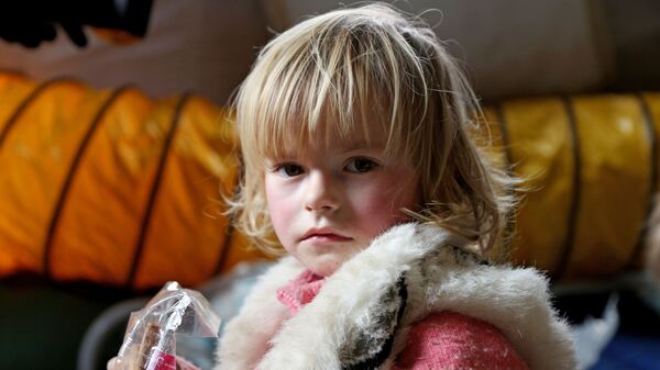 Ребенок беженцев из Мариуполя в пункте оказания помощи эвакуированному населению, который организован МЧС ДНР в селе Безыменное  - Sputnik Latvija