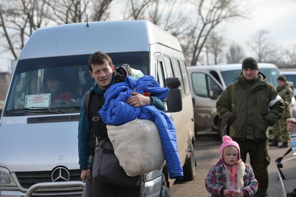 Беженцы из Мариуполя недалеко от пункта оказания помощи эвакуированному населению в селе Безыменное. - Sputnik Латвия