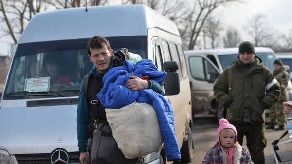 Беженцы из Мариуполя недалеко от пункта оказания помощи эвакуированному населению, который организован МЧС ДНР в селе Безыменное Новоазовского района - Sputnik Латвия
