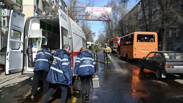 Сотрудники скорой помощи на месте взрыва в центре Донецка после обстрела ракетой Точка-У - Sputnik Латвия
