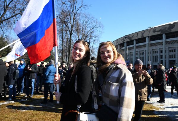 Люди собираются у большой спортивной арены Лужники в Москве перед началом митинга-концерта, посвященного воссоединению Крыма с Россией - Sputnik Латвия