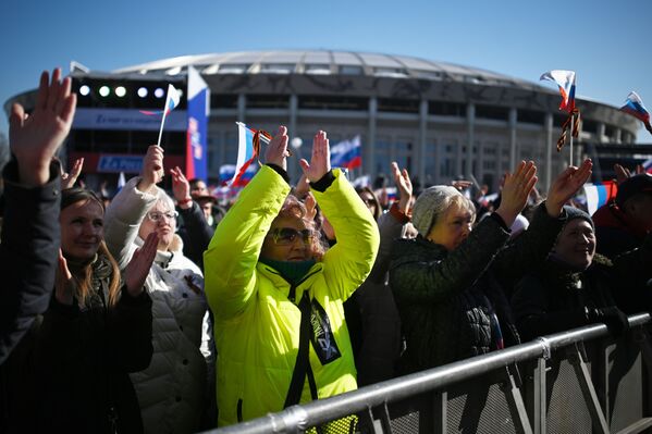 Люди смотрят трансляцию митинга-концерта, посвященного воссоединению Крыма с Россией, у большой спортивной арены Лужники в Москве - Sputnik Латвия