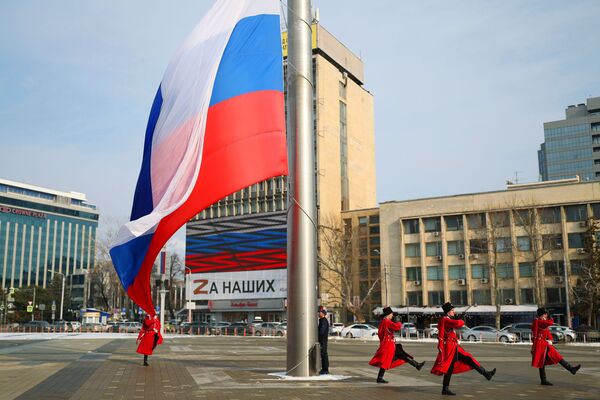 Kubaņas kazaku karaspēka goda sardzes kazaki piedalās Krievijas karoga svinīgajā pacelšanas ceremonijā par godu Krimas atkalapvienošanās dienai ar Krieviju, Krasnodaras galvenais laukums. - Sputnik Latvija