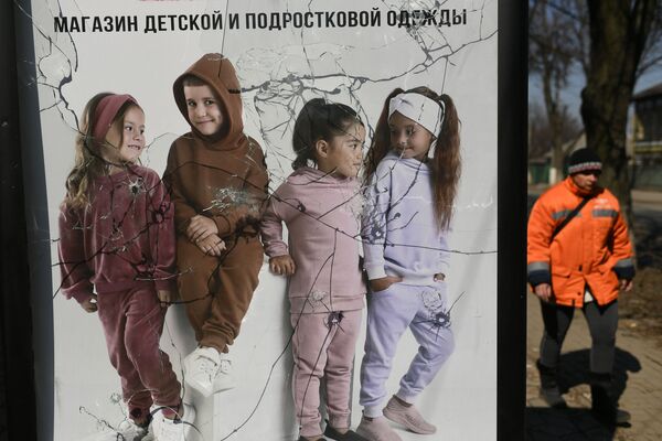 Поврежденный рекламный щит магазина детской и подростковой одежды в Волновахе - Sputnik Латвия