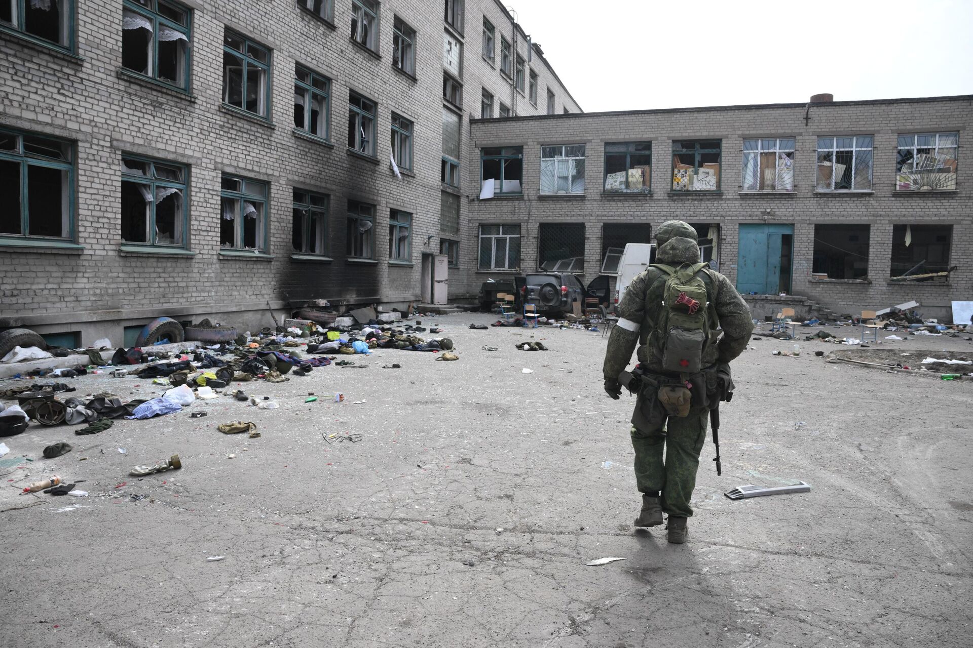 Военнослужащий Народной милиции ДНР у разрушенного здания школы в Мариуполе - Sputnik Latvija, 1920, 14.04.2022