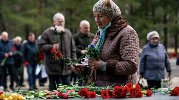Женщина на церемонии возложения цветов на мемориале Саласпилс - Sputnik Латвия